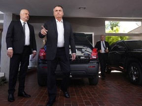 Former Brazilian President Jair Bolsonaro speaks to the press outside his house after Federal Police agents carried out a search and seizure warrant in Brasilia, Brazil, Wednesday, May 3, 2023. When asked about the search of Bolsonaro's home in Brasilia, the Federal Police press office gave a statement saying officers were carrying out searches and arrests related to the introduction of fraudulent data related to the COVID-19 vaccine into the nation's health system.