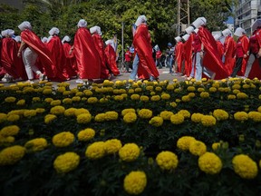 Israeli women's rights activists dressed as characters in the popular television series, "The Handmaid's Tale," protest plans by Prime Minister Benjamin Netanyahu's government to overhaul the judicial system, in Tel Aviv, Israel, Thursday, May 4, 2023.