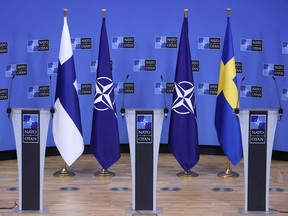 A picture taken at the NATO headquarters in Brussels shows flags of Finland, NATO and Sweden before a press conference