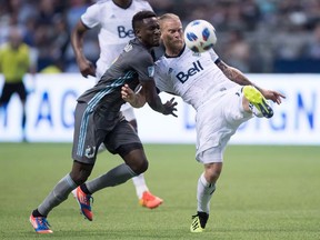 Vancouver Whitecaps' Marcel de Jong, right, kicks the ball away from Minnesota United's Abu Danladi during the second half of an MLS soccer game in Vancouver, on Saturday July 28, 2018. CF Montreal hopes to cap off a run of 11 games in just 36 days with a win against visiting Minnesota United on Saturday.