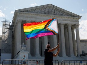 Man waving Pride flag in front of Supreme Court