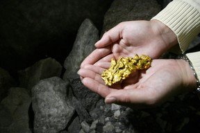 A Natural Resources Canada employee holds a replica gold nugget.