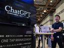 Un representante de stand junto a una pantalla de ChatGPT en la 7.ª Expo de Inteligencia Artificial en Tokio.  El popular chatbot se encuentra deficiente en el departamento de humor.