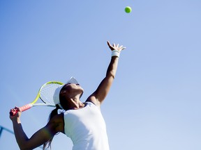 Beautiful female tennis player serving