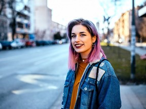 Girl with colorful hair at city street.