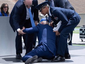 President Joe Biden is helped up after falling