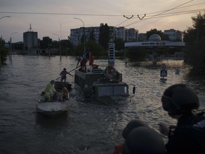 Residents are evacuated from a flooded neighborhood in Kherson