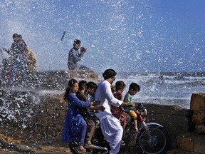 People enjoy high tide waves on the Arabian Sea in Karachi, Pakistan, Sunday, June 11, 2023. Pakistani Prime Minister Shehbaz Sharif ordered officials to put in place emergency measures in advance of the approaching Cyclone Biparjoy in the Arabian Sea. The "severe and intense" cyclone with wind speeds of 150 kilometers per hour (93 miles per hour) was on a course toward the country's south, Pakistan's disaster management agency said.