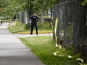 A police officer surveys the scene near the Guru Nanak Sikh Gurdwara Sahib temple after a shooting in Surrey, B.C., Monday, June 19, 2023. A close associate of Sikh community leader Hardeep Singh Nijjar says his friend was warned by Canadian intelligence officials about being targeted for assassination by "mercenaries" before being gunned down on Sunday in Surrey.