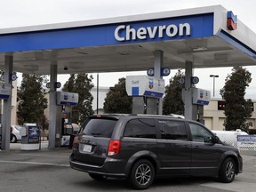 FILE - A motorist drives near the pumps at a Chevron gas station in Oakland, Calif. Tuesday, April 25, 2017. California jury has returned a $63 million verdict against Chevron after finding the oil giant covered up a toxic chemical pit and then sold the land to a man who built a house on it and was later diagnosed with a blood cancer.