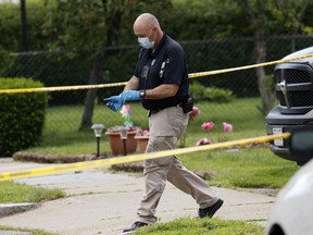 An investigator walks out of a home