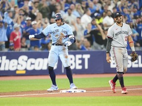Toronto Blue Jays' George Springer (4) celebrates beside Minnesota Twins third baseman Royce Lewis (23) after coming in for a pinch hit RBI double during the sixth inning of MLB American League baseball action in Toronto on Friday, June 9, 2023.