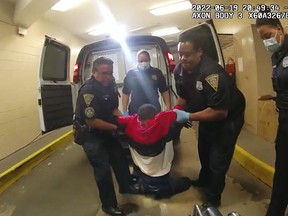 FILE - In this image taken from police body camera video provided by New Haven, Conn., Police, Richard "Randy" Cox, center, is pulled from the back of a police van and placed in a wheelchair after being detained by New Haven Police on June 19, 2022, in New Haven, Conn. The City of New Haven fired two police officers Wednesday, June 7, 2023, for what authorities called their reckless actions and lack of compassion toward Cox, who was injured and became paralyzed in the back of a police van after his arrest last year. (New Haven Police via AP, File)