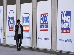 A man walks past the News Corp. and Fox News headquarters on April 19, 2023, in New York. An advocacy group that wants the Canadian Radio-television and Telecommunications Commission to ban Fox News says the network's "abusive content" extends beyond its divisive personalities such as recently fired host Tucker Carlson.