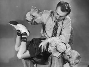 A man spanking a young boy.