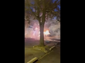 In this image made from video provided, a vehicle is on fire in the middle of a road as fireworks explode in Nanterre, France, Tuesday, June 27, 2023.