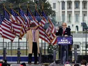 FILE - Chapman University law professor John Eastman stands at left as former New York Mayor Rudolph Giuliani speaks in Washington at a rally in support of President Donald Trump, called the "Save America Rally" on Jan. 6, 2021. An effort to disbar Eastman, who devised ways to keep former President Donald Trump in the White House after his defeat the 2020 election, will begin Tuesday, June 20, 2023, in Los Angeles. Eastman is expected to spend the day testifying before the State Bar of California in a proceeding that could result in him losing his license to practice law in the state.