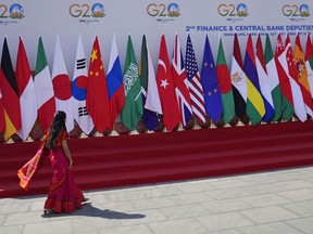 FILE- A delegate walks past a display of flags of participating countries at the venue of G-20 financial conclave on the outskirts of Bengaluru, India, Wednesday, Feb. 22, 2023. India is not planning to invite Ukraine to the summit of the Group of 20 industrialized and developing nations in September, its external affairs minister said Thursday, June 8, 2023. "In our view, G20 participation is for members and organizations we have invited. That list we declared as soon as we assumed the G20 presidency" in December, Subrahmanyam Jaishankar told reporters.