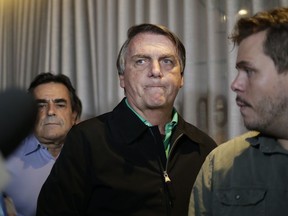 Brazil's former President Jair Bolsonaro prepares to speak to the press at a restaurant in Belo Horizonte, Brazil, Friday, June 30, 2023. The panel of judges voted Friday to render Bolsonaro ineligible to run for office again after concluding that he abused his power and cast unfounded doubts on the country's electronic voting system.