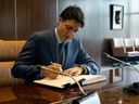 Canadian Prime Minister Justin Trudeau signs a guestbook during a meeting with with UN Secretary-General Antonio Guterres at UN headquarters in New York City on July 21, 2023.