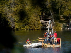 Tim Patterson, Professor of Geology at Carleton University (R) leads a team of scientists as they retrieve a probe from the bottom of Crawford Lake while gathering sediment layer samples at Crawford Lake near Milton, Ontario, Canada, April 12, 2023.