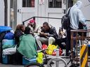 Asylum seekers sit with their belongings outside a City of Toronto assessment and referral centre for the homeless, where some say they have been living on the pavement for as many as six weeks because the city's shelters are full. They were sent to the referral centre after landing at Pearson International Airport.