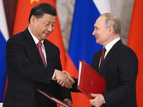 Chinese President Xi Jinping and Russian President Vladimir Putin shake hands during a signing ceremony following talks at the Kremlin on March 21, 2023.