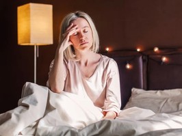 Middle age woman sitting in a bed having trouble sleeping