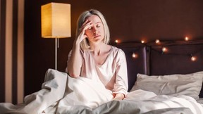 Middle age woman sitting in a bed having trouble sleeping