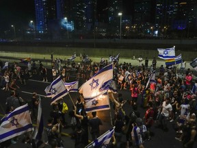 Israelis block a highway as they protest against plans by Prime Minister Benjamin Netanyahu's government to overhaul the judicial system, in Tel Aviv, Israel, Tuesday, July 18, 2023.