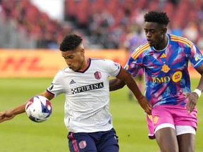 St. Louis City's Nicholas Gioacchini (left) battles for the ball with Toronto FC's Aime Mabika during first half MLS action in Toronto, on Saturday, July 8, 2023.THE CANADIAN PRESS/Chris Young