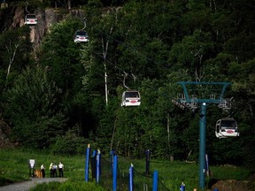 Cadets from the Surete du Quebec stand near the base of a chairlift where one person died and another remains critically injured after a gondola crashed into a piece of construction equipment at Mont-Tremblant Resort in Mont-Tremblant, Que., on Sunday, July 16, 2023.