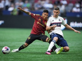 Vancouver Whitecaps' Ranko Veselinovic, right, stops a pass intended for Seattle Sounders' Raul Ruidiaz during the first half of an MLS soccer match in Vancouver, on Saturday, July 8, 2023.