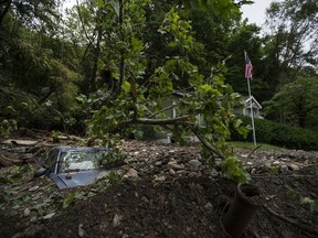 A car is buried in mud and rocks from recent flooding, Monday, July 17, 2023, in Belvidere, New Jersey.