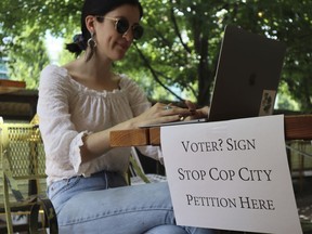 Activist Hannah Riley works on her laptop at Muchacho, a local taco restaurant, while gathering signatures from fellow voters, in Atlanta, Thursday, July 13, 2023. Organizers are trying to force a referendum that would allow voters to decide the fate of a proposed police and training center, but attorneys for the city say the petition drive is invalid.
