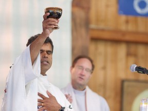 Rev. Susai Jesu (left), pastor, Sacred Heart Church of the First Peoples, Edmonton, and Rev. Mark Blom, associate pastor, Sacred Heart Church of the First Peoples take part in an an impromptu mass at the Lac Ste. Anne Pilgrimage in Lac Ste. Anne, Alta. in this Tuesday, July 25 handout photo.
