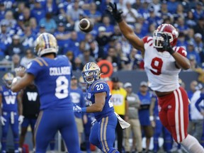 Winnipeg Blue Bombers quarterback Zach Collaros (8) throws to Brady Oliveira (20) with pressure from Calgary Stampeders' James Vaughters (9) during first half CFL action in Winnipeg Friday, July 7, 2023.