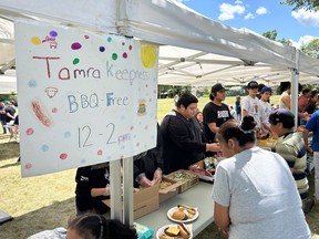 People line up for food at an annual barbecue to mark the disappearance of Tamra Keepness, in Regina, Wednesday, July 5, 2023. Keepness was last seen in her home in Regina on July 5, 2004.