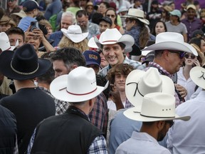 Prime Minister Justin Trudeau, centre, walks the grounds of the Calgary Stampede in Calgary, Friday, July 7, 2023.