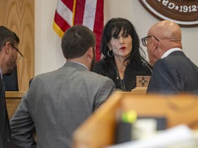 Second Judicial District Judge Cindy Leos talks with prosecutors and defense attorney Paul Kennedy, at right, former University of New Mexico athletic director Paul Krebs' trial in Albuquerque, N.M., Wednesday, July 19 2023. Krebs left the university in 2017 amid questions over spending and was later indicted by a grand jury on multiple charges that stemmed from allegations that he used public money for a lavish golf trip that he said was meant to strengthen relationships with donors.