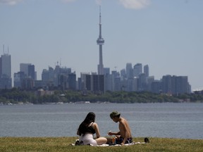 People eat lunch on a hot day in Toronto on Thursday, June 23, 2022. It is expected to feel like 40 degrees across large parts of Ontario and Quebec as a heat wave continues.THE CANADIAN PRESS/Nathan Denette