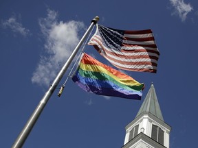 FILE - A gay Pride rainbow flag flies with the U.S. flag in front of the Asbury United Methodist Church in Prairie Village, Kan., on Friday, April 19, 2019. As of June 2023, more than 6,000 United Methodist congregations -- a fifth of the U.S. total -- have now received permission to leave the denomination amid a schism over theology and the role of LGBTQ people in the nation's second-largest Protestant denomination.