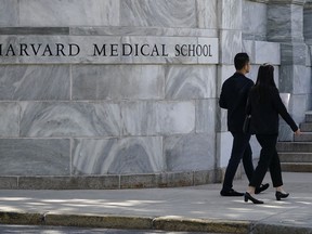 Pedestrians walk towards the Harvard Medical School in Boston