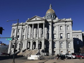 FILE - A cyclist passes by the Colorado Capitol building, Jan. 15, 2021, in Denver. Two Democratic representatives in Colorado filed a lawsuit on Friday, July 7, 2023, against their own caucus alleging that their colleagues repeatedly violated state open meetings law by gathering to discuss official business outside of the public's view and directing aides to "omit or disguise" some meetings from representatives' calendars.
