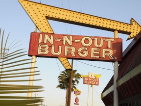 FILE - In-N-Out Burger signs fill the skyline on Tuesday, June 8, 2010, in Calif. In-N-Out is barring employees in five states from wearing masks unless they have a doctor's note, according to internal company emails leaked on social media last week.