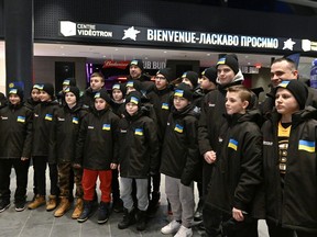 Ukrainian peewee hockey team players and coaches pose for a group photo as they arrive, Wednesday, Feb. 1, 2023, at the Vidéotron Centre in Quebec City. Six teens who came to Quebec City earlier this year as part of a Ukrainian squad to play in the city's famed peewee hockey tournament will be returning next month to go school in the provincial capital.