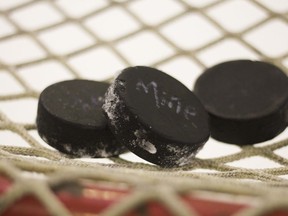 Hockey pucks hang on a goal net in a Monday, Feb. 27, 2012 file photo. BC Hockey will have a new junior-A system in place for the 2023-24 season. The provincial sports organization will promote all three of its junior B leagues to junior A.THE CANADIAN PRESS/AP Ariel Schalit