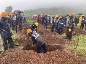 Rescuers dig a grave to bury a victim of a landslide in Raigad district, in India's western Maharashtra state, Thursday, July 20, 2023. A landslide triggered by torrential rains killed five people, with many others feared trapped under piles of debris, local media reported Thursday.