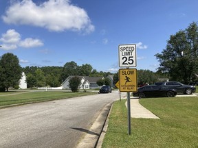 The entrance to the Dogwood Lakes neighborhood in Hampton, Ga., is shown on Sunday, July 16, 2023, with a police car to the left. Police say a man shot and killed four people in the neighborhood on Saturday, July 15, 2023.