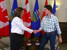 Danielle Smith and Justin Trudeau shake hands.